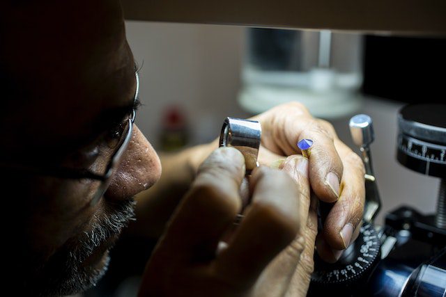 a man inspecting a gemstone