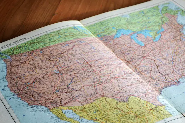 map of the world book laid open on brown wooden surface