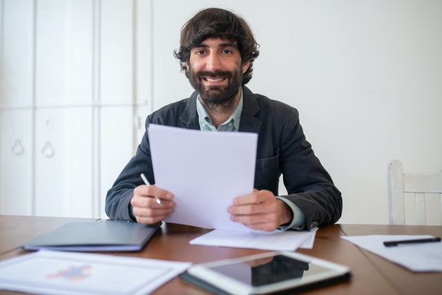 pexels-bearded-man-in-black-jacket-holding-papers