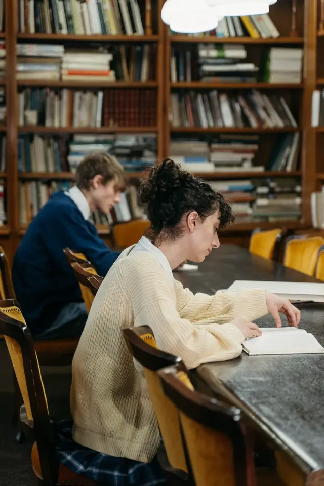 University Student Reading Book In Library