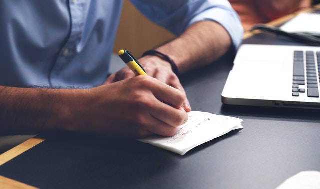 Pexels person-writing-on-paper-using-yellow-and-black-pen