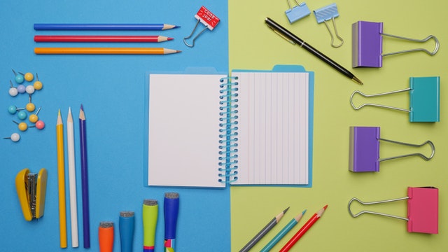 pexels-colorful pens and stationaries on a blue and yellow surface
