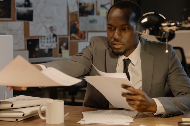 pexels-man in suit holding white paper