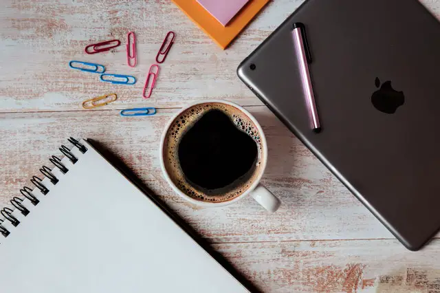 Silver ipad and coffee cup.