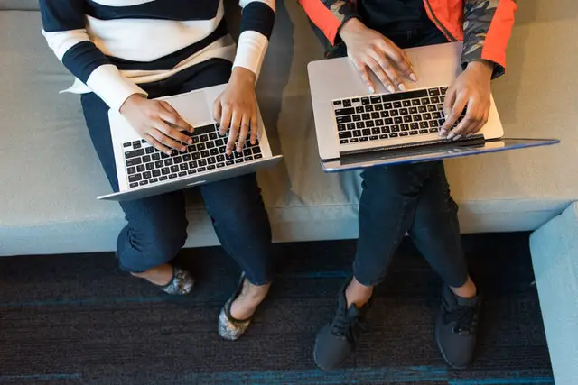 pexels-two people holding laptop