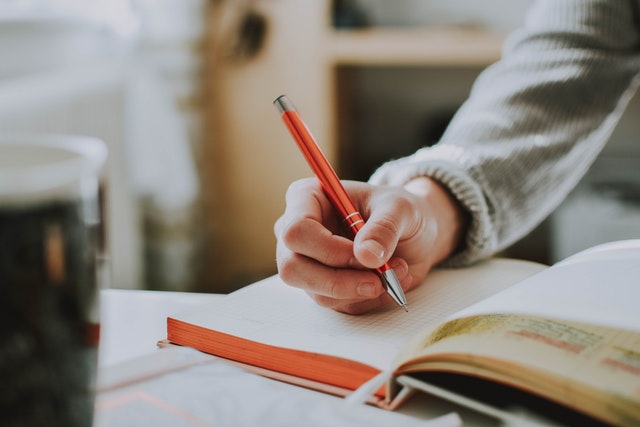 Student writing on a book