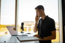 Man on a call and inn front of a laptop