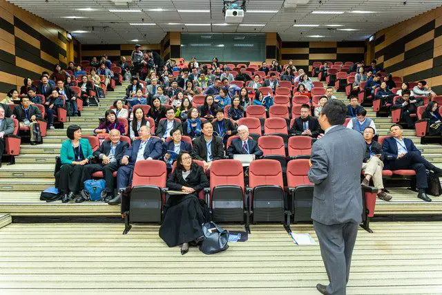 pexels - Man standing in front of people ina hall