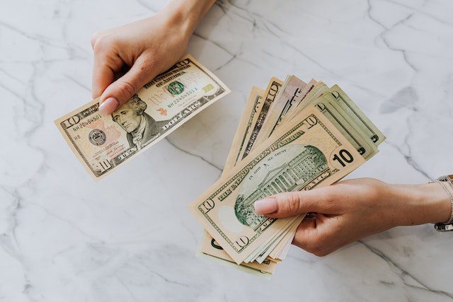 Pexels - Hands holding US dollar bills