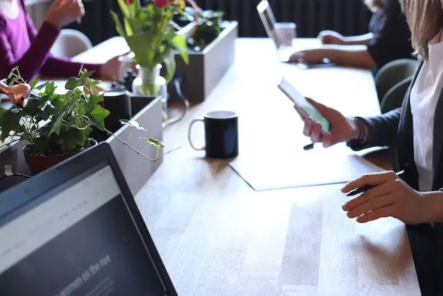 Pexels - Person holding smartphone in front of table