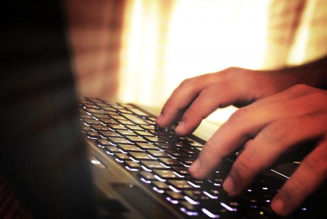 hands typing on laptop keyboard