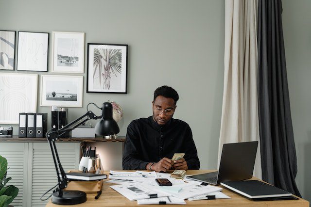 Pexels - Man in black shirt counting money on a table