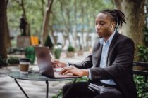 Young man with dreadlocks working on a laptop