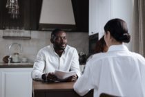 Afro-American Man and Caucasian Woman Having Meeting at Home with Social Worker