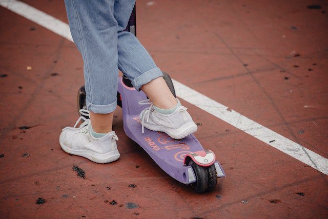 kid on scooter in sports area