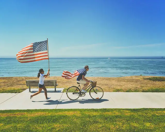 Unsplash - two people running with the flag of America