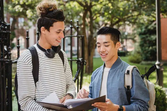 Cheerful multiethnic students sharing information about studying