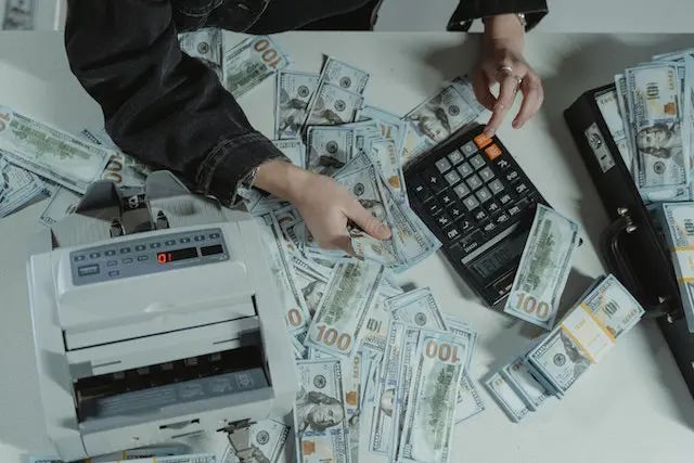 Pexels - Person Holding Dollar Bills while Using a Calculator