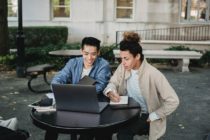 Positive multiethnic students using laptop for studies
