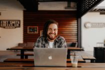Unsplash - A smiling man in front of a laptop