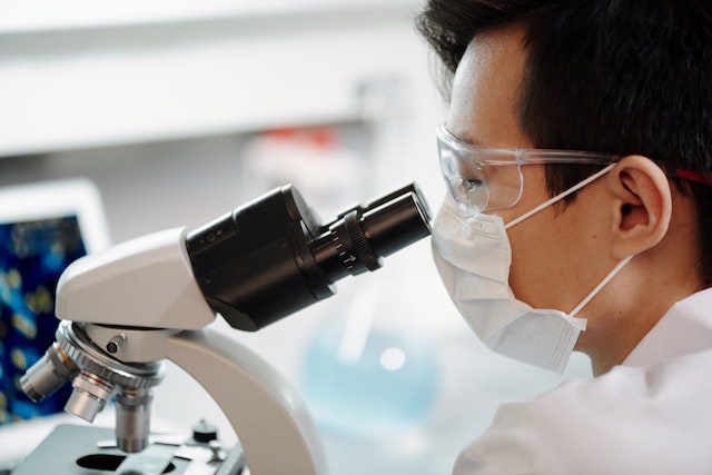 Man Looking Through A Microscope