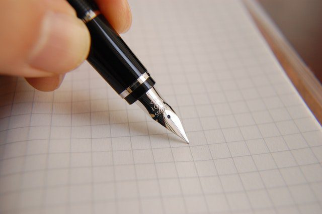 writing on a paper with a pen