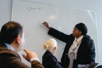 Professional Woman Discussing on White Board