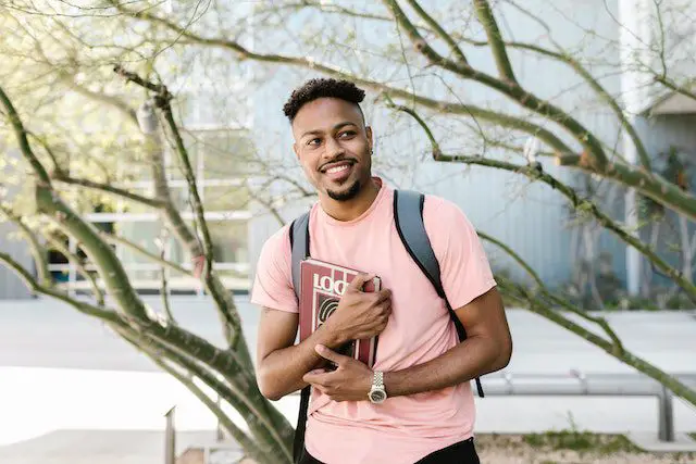 Man Wearing a T-shirt Holding a Book