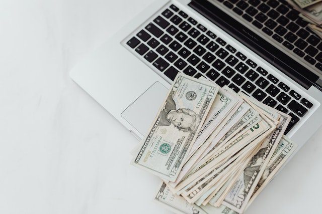 Close-Up Photo of Banknotes on Top of a Laptop's Keyboard