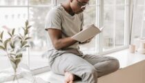 A Man in Gray Shirt Reading a Book