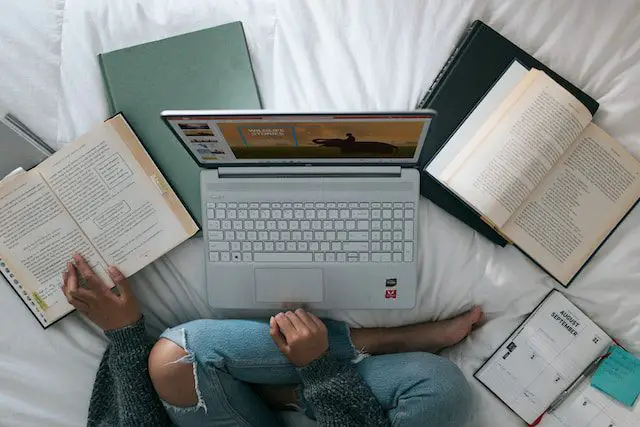 Laptop and books on the bed