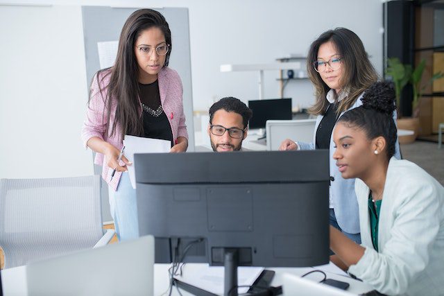 People in the Office Using a Desktop Computer for Discussion