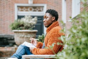 Pensive black man studying on street