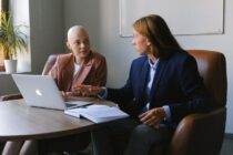 Man and woman discussing project strategy while sitting with laptop