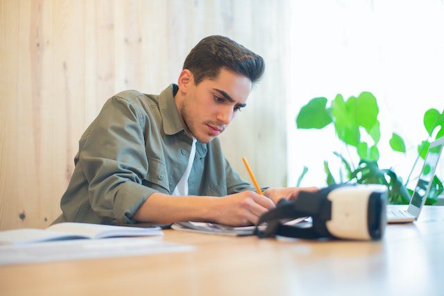 A Man in Polo Shirt Writing