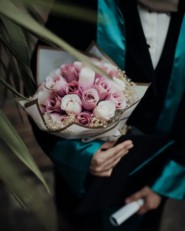 Pexels- Women in academic gown holding flowers