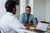 A Smiling Man Looking at His Colleague