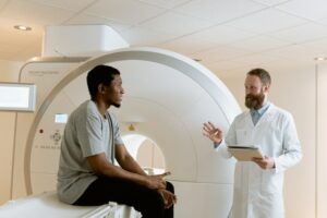 Photo Of Man Sitting On A CT Scanner
