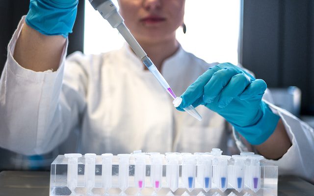 Unsplash - Female scientist putting chemicals in a test tube
