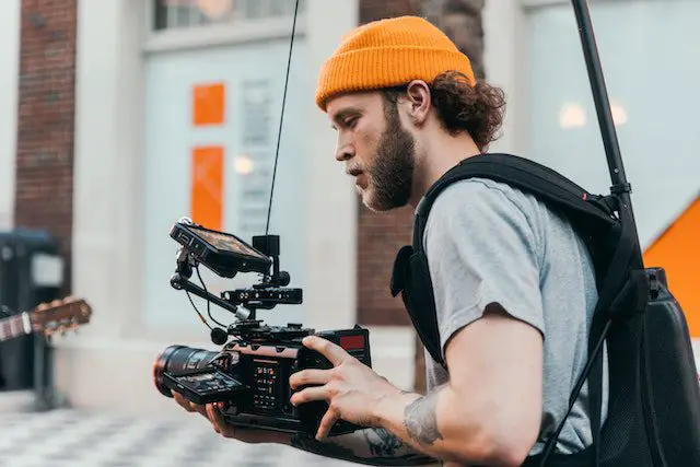 Man in Gray Crew Neck T-shirt Using Black Video Camera