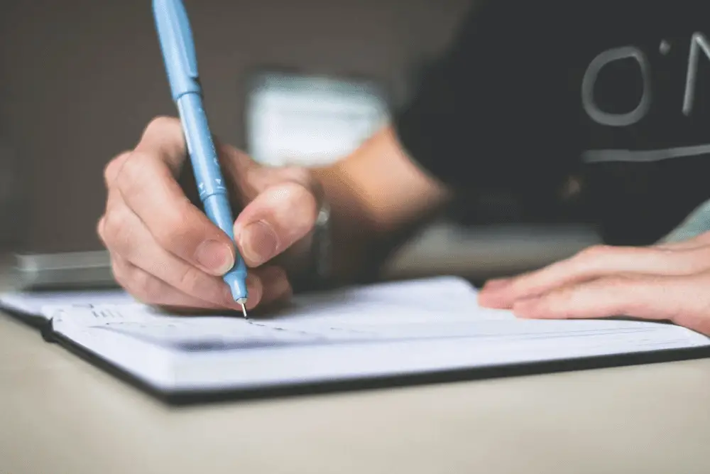 Person Writing on a Notepad