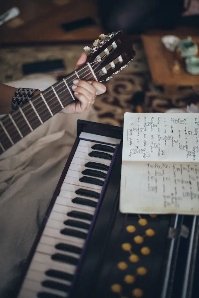 person playing guitar with music notes