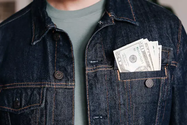 crop-man-with-dollar-banknotes-in-pocket-of-jacket