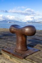 a rusted metal object sitting on top of a wooden dock