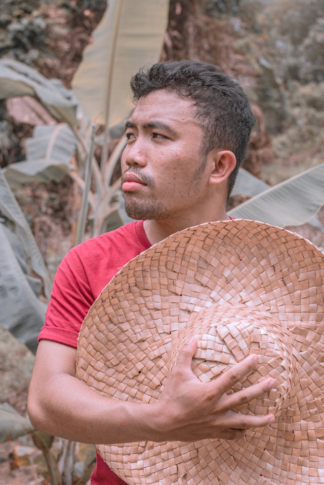 a man holding his straw hat