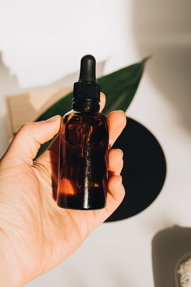 person holding brown glass bottle