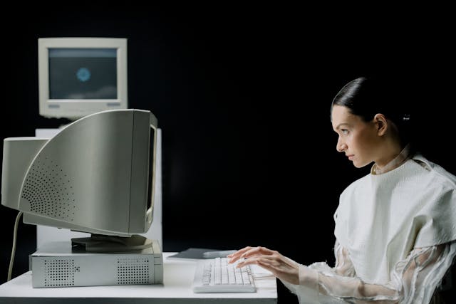 woman in white clothing using a computer
