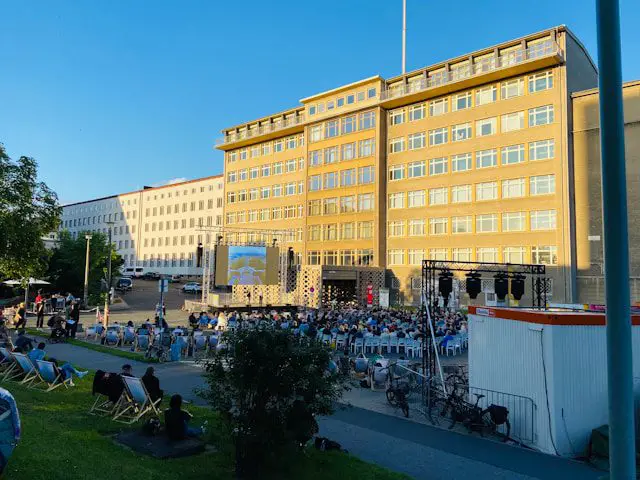 a group of people sitting in lawn chairs in front of a building