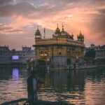 man riding on boat near golden mosque
