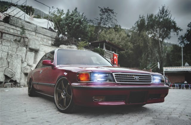 red toyota sedan with headlights on